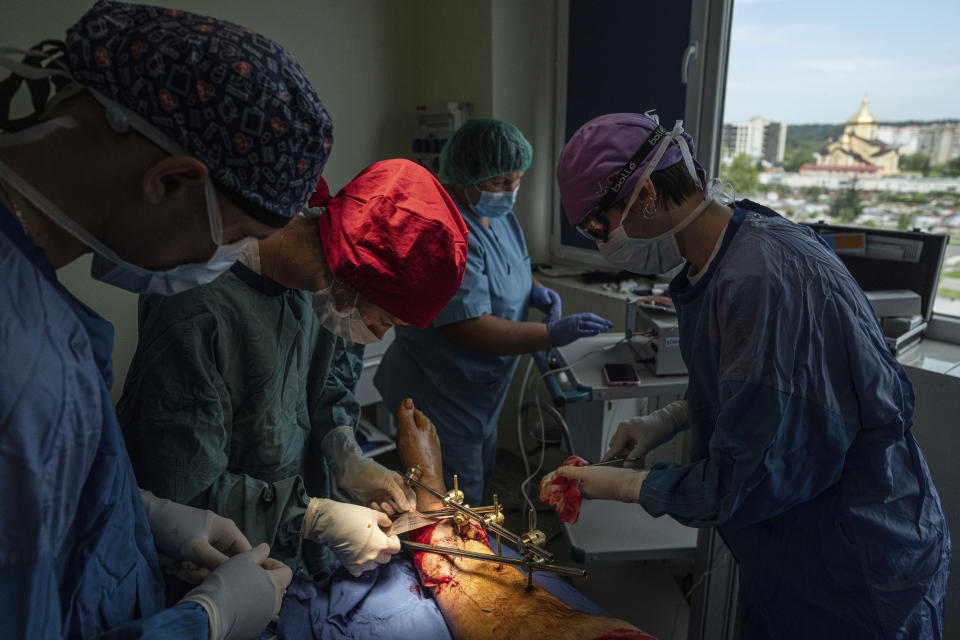 Surgeons transplant skin onto the foot of a Ukrainian soldier at St. Panteleimon hospital in Lviv, Ukraine, Tuesday, July 25, 2023. Ukraine is facing the prospect of a future with upwards of 20,000 amputees, many of them soldiers who are also suffering psychological trauma from their time at the front. (AP Photo/Evgeniy Maloletka)