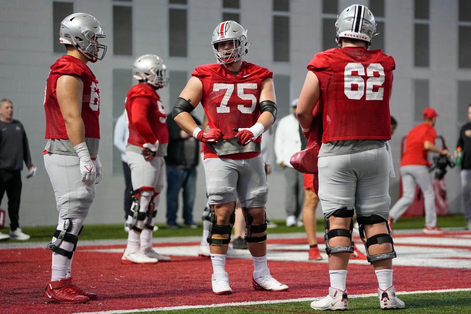 Mar 7, 2023; Columbus, Ohio, USA;  Ohio State Buckeyes Carson Hinzman (75) talks to fellow offensive linemen Enokk Vimahi (66) and Josh Padilla (62) during spring football drills at the Woody Hayes Athletic Center. Mandatory Credit: Adam Cairns-The Columbus Dispatch