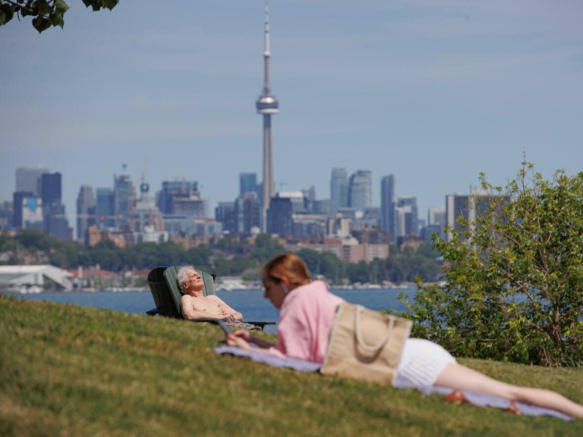 Sunbathers recline at Humber Bay Shores Park in Toronto on Jun. 8. Environment Canada has issued a heat warning for Toronto, with temperatures predicted to reach the low 30s on Sunday. (Evan Mitsui/CBC - image credit)