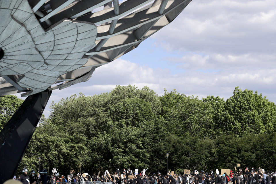 Protesters march a round large sculpture of a globe in Flushing Meadows Corona Park in the Queens borough of New York, Sunday, May 31, 2020. Demonstrators took to the streets of New York City to protest the death of George Floyd, a black man who was killed in police custody in Minneapolis on May 25. (AP Photo/Seth Wenig)