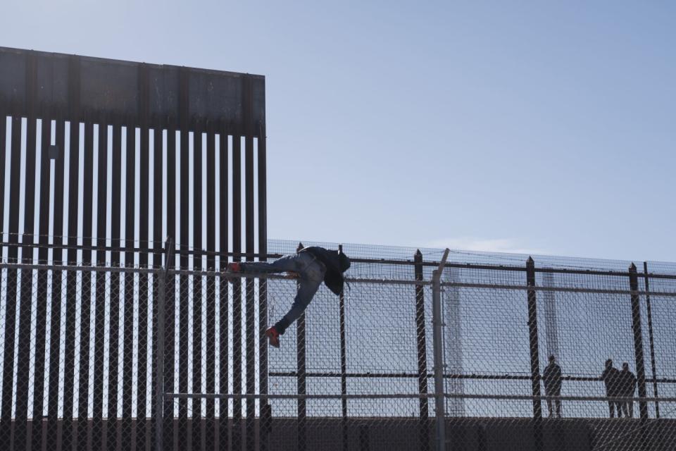 A person climbing over a fence