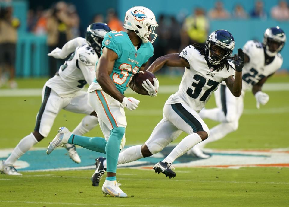 Miami Dolphins running back Raheem Mostert (31) runs a play as Philadelphia Eagles cornerback Mac McCain III (37) is in pursuit during the first half of a NFL preseason football game, Saturday, Aug. 27, 2022, in Miami Gardens, Fla. (AP Photo/Wilfredo Lee)