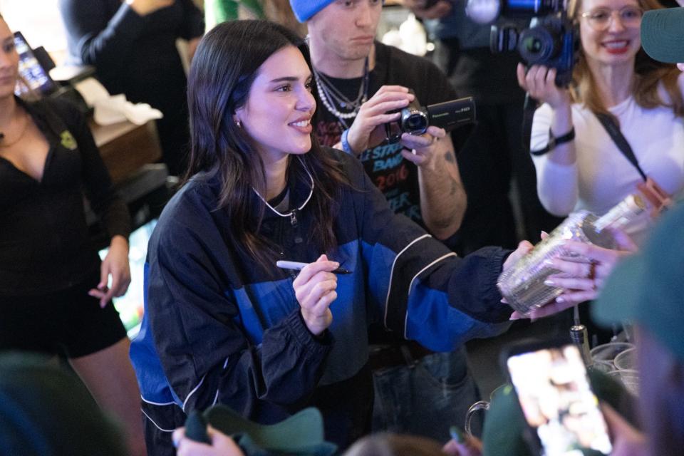 Kendall Jenner signs a bottle at The Swamp Restaurant on Wednesday in Gainesville.