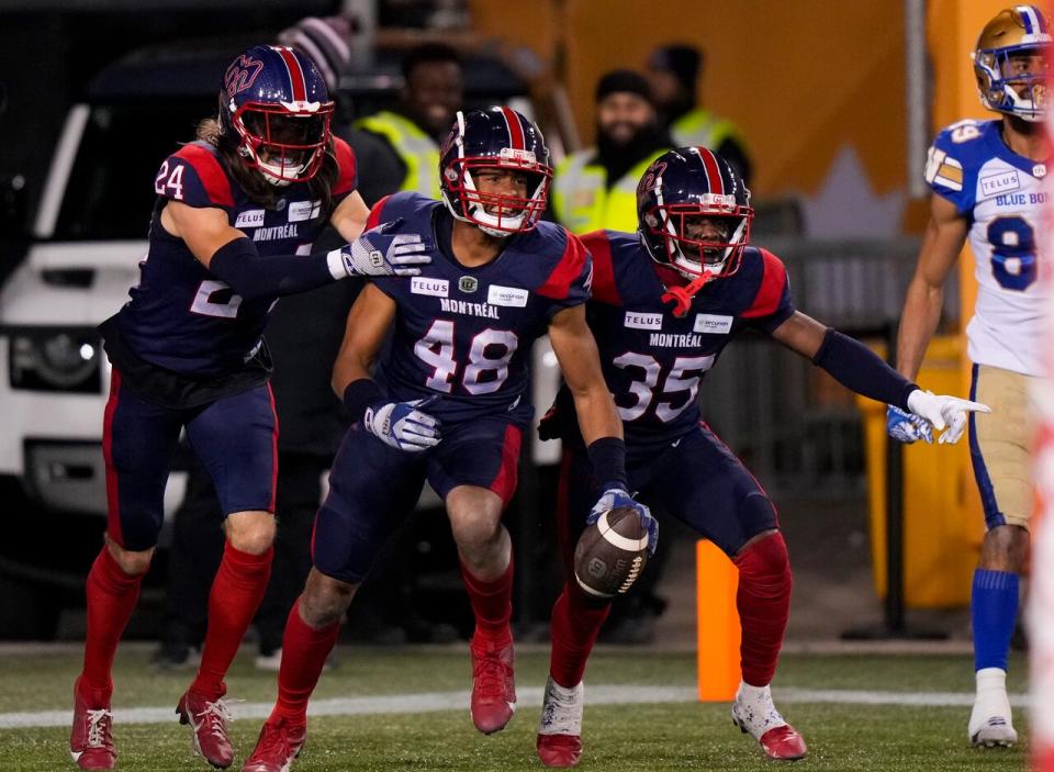 Montreal Alouettes defensive back Kabion Ento (48) celebrates with defensive backs Reggie Stubblefield (35) and Marc-Antoine Dequoy (24) after intercepting a pass during a 28-24 win over the Winnipeg Blue Bombers at the 110th CFL Grey Cup in Hamilton, Ont., on Sunday. (Frank Gunn/The Canadian Press - image credit)