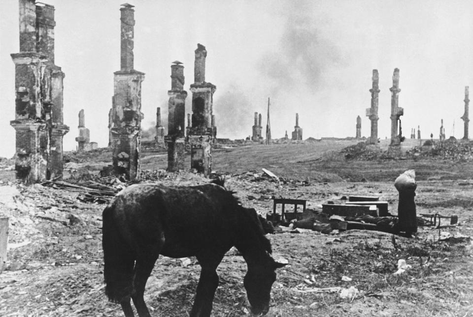 FILE - An abandoned horse grazes among the ruins of the Russian city of Stalingrad, now Volgograd, on Dec. 18, 1942, about four months into the battle for the city on the Volga River between Axis forces and the Soviet army. In the background, at right, Russian women leaving their battered homesteads make their way through the ruins. World War II inflicted colossal suffering on the Soviet Union, but cemented its status as a superpower and swelled citizens' hearts with the conviction that it was a virtuous and indomitable nation. An estimated 27 million Soviets died in the conflict. The Battle of Stalingrad was one of the bloodiest in the history of warfare. (AP Photo/Alvin Steinkopf, File)