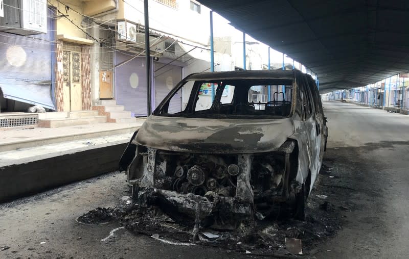 A burnt car is seen along a deserted street in the town of Ras al-Ain