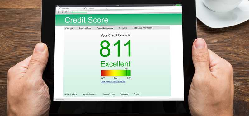 man holding tablet displaying credit score of 811 and word excellent