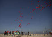 Red balloons are released to honor the victims of COVID-19 in a demonstration organized by Rio de Paz, on Copacabana beach in Rio de Janeiro, Brazil, Saturday, Aug. 8, 2020, as the country heads to a milestone of 100,000 new coronavirus related deaths. (AP Photo/Silvia Izquierdo)