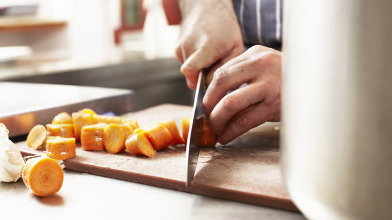 Hands slicing carrots