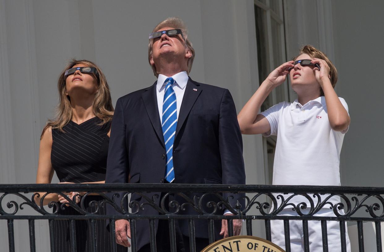 Former President Donald Trump, former First Lady Melania and son Barron look up at the solar eclipse from the balcony of the White House in Washington, D.C, on Aug. 21, 2017.