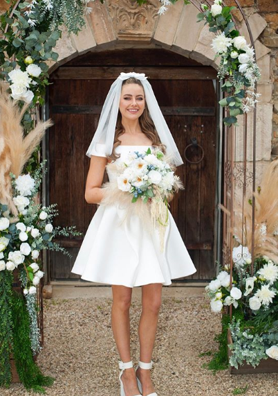 A photo of April Rose Pengilly wearing a white wedding dress on set of her TV wedding on Neighbours.