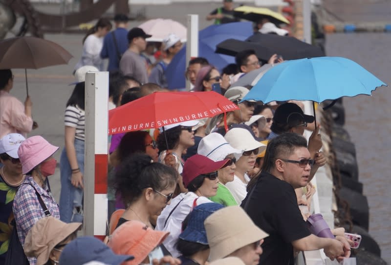 高雄天氣晴朗  大港橋現人潮（2） 中央氣象署22日指出，受西南風影響，天氣高溫炎 熱，中午前後高雄市、台南市地區為橙色燈號，有攝 氏38度極端高溫出現。圖為高雄大港橋一帶出遊民眾 撐傘、戴墨鏡遮陽。 中央社記者董俊志攝  113年4月22日 