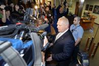 REFILE - CORRECTING IDENTITY City councillor Doug Ford, brother of Toronto Mayor Rob Ford, speaks to the media after a special council meeting at City Hall in Toronto November 18, 2013. Toronto's City Council voted overwhelmingly on Monday to limit further the powers of embattled Toronto Mayor Rob Ford, who denounced the move as a coup d'etat and warned political foes of an election battle next year to rival the Gulf War. Ford has been under fire after admitting to smoking crack cocaine, buying illegal drugs and driving after drinking alcohol. REUTERS/Aaron Harris (CANADA - Tags: POLITICS DRUGS SOCIETY MEDIA)