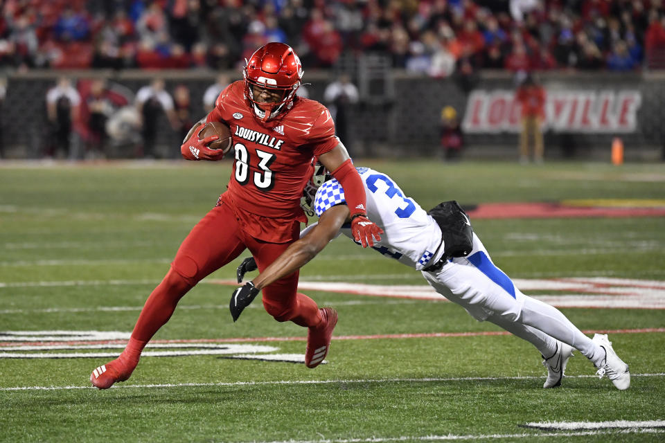 Louisville tight end Marshon Ford (83) is tackled by Kentucky defensive back Jalen Geiger (34) during the first half of an NCAA college football game in Louisville, Ky., Saturday, Nov. 27, 2021. (AP Photo/Timothy D. Easley)