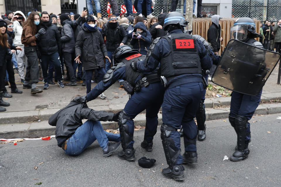 Riot police officers detain a protestor during a demonstration against pension changes, Thursday, Jan. 19, 2023 in Paris. Workers in many French cities took to the streets Thursday to reject proposed pension changes that would push back the retirement age, amid a day of nationwide strikes and protests seen as a major test for Emmanuel Macron and his presidency. (AP Photo/Lewis Joly)