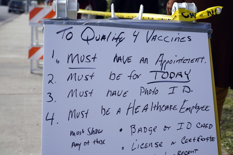 A sign describes the requirements to receive a COVID-19 vaccine at a site for health care workers at Ritchie Valens Recreation Center Wednesday, Jan. 13, 2021, in Pacoima, Calif. (AP Photo/Marcio Jose Sanchez)