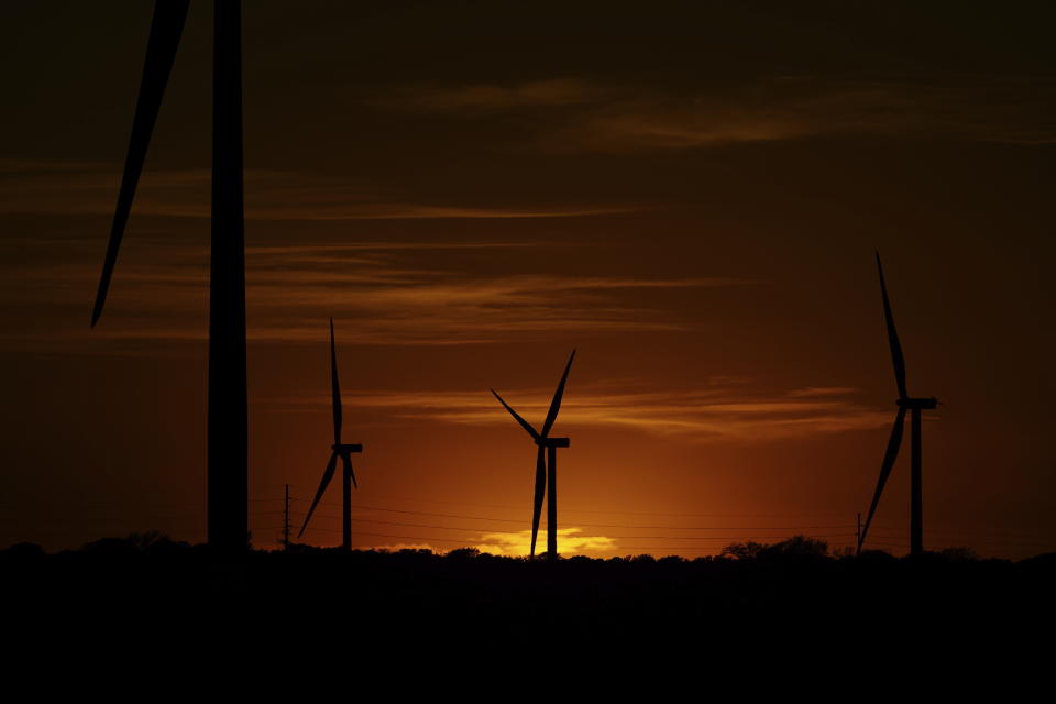Wind turbines are seen at sunset on a wind farm near Del Rio, Texas, Wednesday, Feb. 15, 2023. Across Europe companies are weighing up the U.S. Inflation Reduction Act's $375 billion in benefits for renewable industries against the European Union's fragmented response.(AP Photo/Eric Gay)