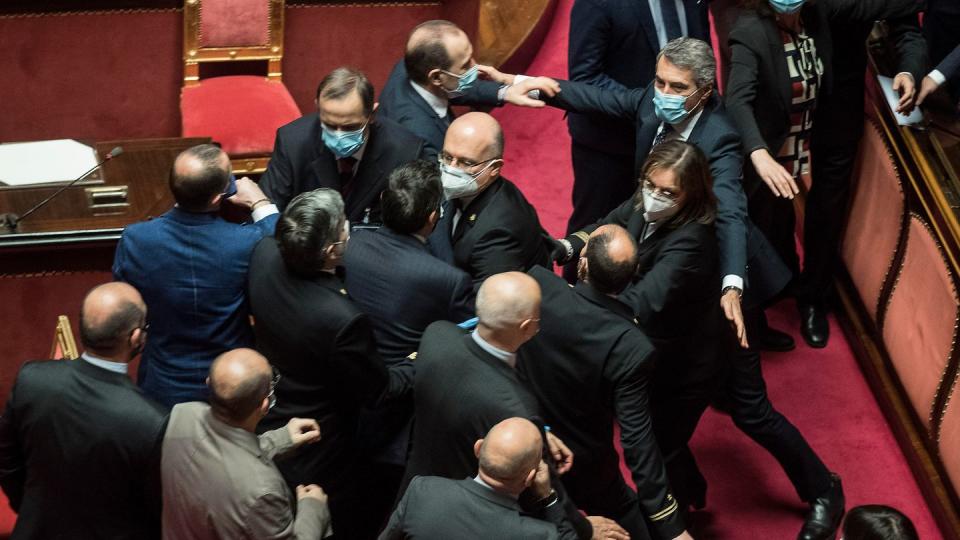 Platzanweiser (M) verhindern, dass Senatsmitglieder der Lega Nord (l) mit Mitgliedern der Demokratischen Partei im Senat aneinandergeraten.