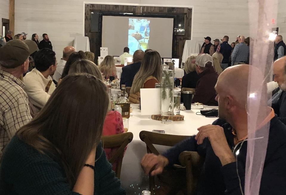 At "Light the Community" fundraising event, Taylor Lee and his wife Wendy watch a slideshow of his dad Daniel Lee's recovery after he received both a heart and liver transplant.