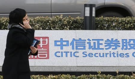 A woman walks past a signboard of CITIC Securities at its head office in Beijing March 27, 2013. REUTERS/Kim Kyung-Hoon