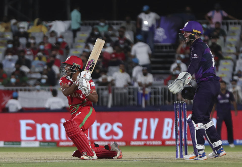 Oman's batsman Suraj Kumar, left, watches his short ball as Scotland's wicketkeeper Matthew Cross reacts during the Cricket Twenty20 World Cup first round match between Oman and Scotland in Muscat, Oman, Thursday, Oct. 21, 2021. (AP Photo/Kamran Jebreili)