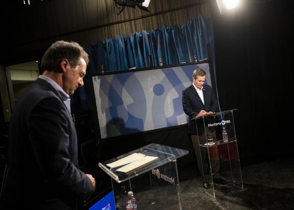 FILE - In this Sept. 28, 2020, file photo, Gov. Steve Bullock, left, and U.S. Sen. Steve Daines, R-Mont., prepare their notes before the beginning of their televised debate at the KUFM-TV studio at the University of Montana in Missoula, Mont. Political groups fighting for control of the U.S. Senate have poured more than $118 million into the contest between Bullock and Daines. For Montana residents, it means an unrelenting barrage of advertisements any time they turn on their computers, televisions and radios or open their mailboxes. (Ben Allan Smith/The Missoulian via AP, File)