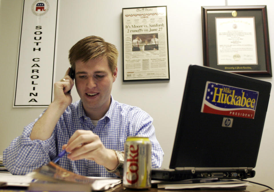 FILE - In this Dec. 28, 2007, file photo, Adam Piper, one of only four full-time staffers for Mike Huckabee's presidential campaign in South Carolina, answers calls and returns emails from the state campaign headquarters in Columbia, S.C. Piper, the executive director of a national group that advocates for Republican attorneys general, resigned from the association five days after the Jan. 6, 2021 violence in Washington. (AP Photo/Brett Flashnick, File)
