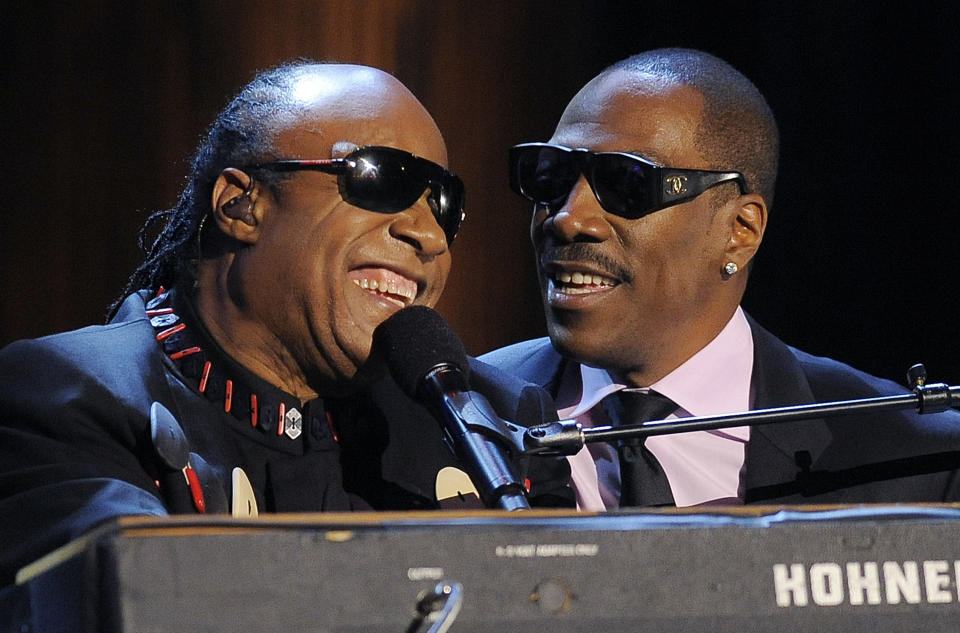 Stevie Wonder, left, is joined by Eddie Murphy to sing Wonder's song "Higher Ground" onstage during "Eddie Murphy: One Night Only," a celebration of Murphy's career at the Saban Theater on Saturday, Nov. 3, 2012, in Beverly Hills, Calif. (Photo by Chris Pizzello/Invision)