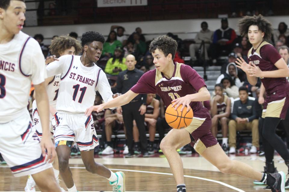 Iona Prep's Lucas Morillo (11, red) tries to drive past St. Francis Prep's Nigel Moore (11, white) during the CHSAA AA city quarterfinals at Fordham University on March 5, 2023.