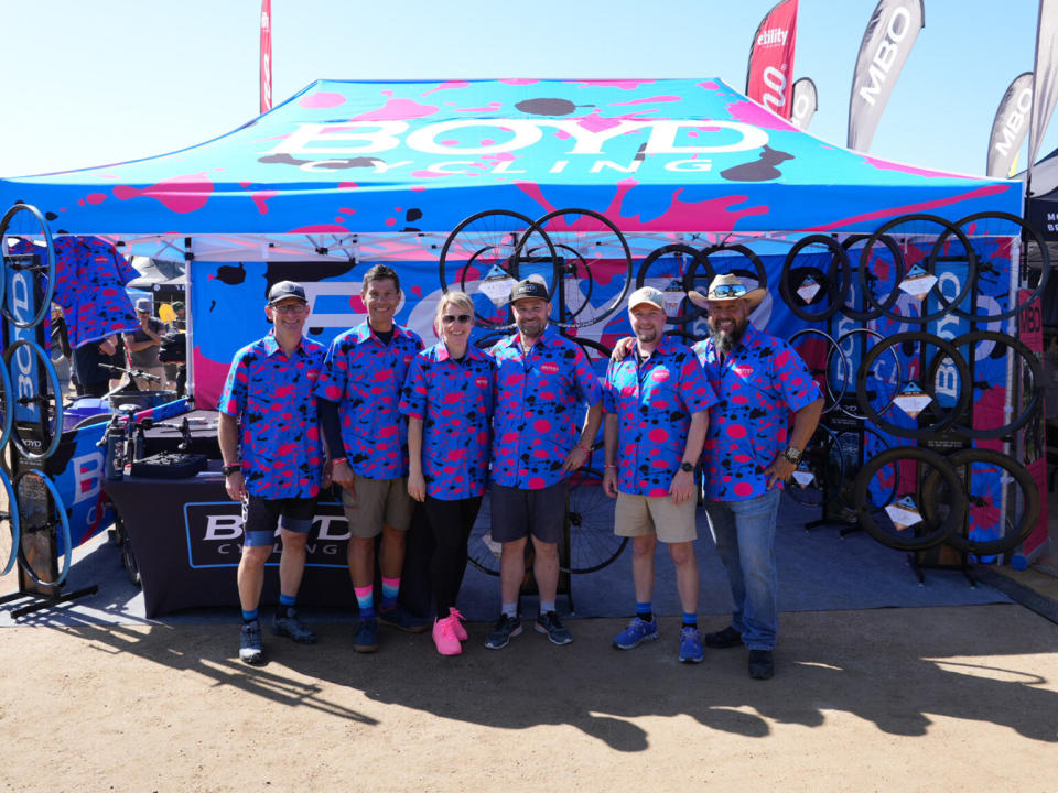 boyd cycling employees in very bright pink and blue polka dot shirts