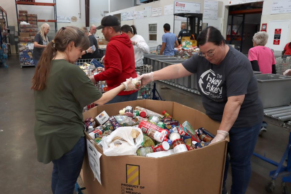 Volunteers Kelly Beals and Sherri Kizziar determine which bins the food go in as they sort food Oct. 26 at the High Plains Food Bank.