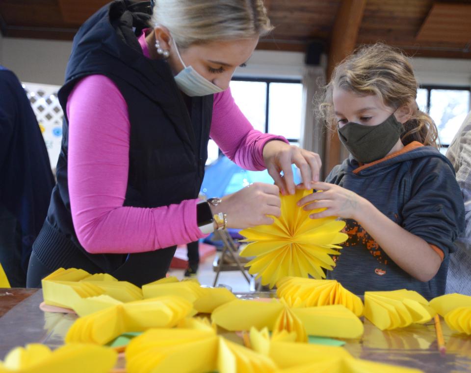 Lilly Morse, left, helps Lydia Garrison craft a sunflower out of paper during a 2022 drop-in "Family Day" event hosted by the St. Barnabas's Episcopal Church in Falmouth to help parents and children discuss the war in the Ukraine.