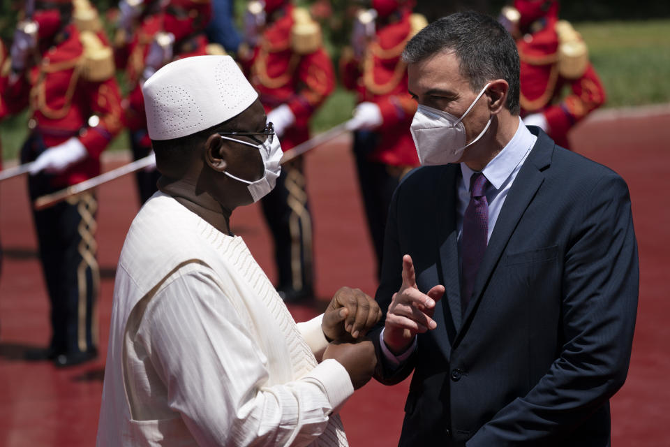 Senegal's President Macky Sall, left, welcomes Spanish Prime Minister Pedro Sanchez prior to a meeting at the presidential palace in Dakar, Senegal, Friday, April 9, 2021. Sanchez is on a mini-tour to Angola and Senegal that are key in the European country's new push to bolster ties with the neighboring continent and mitigate the migration flows that many fear could increase as a consequence of the coronavirus pandemic. (AP Photo/Leo Correa)