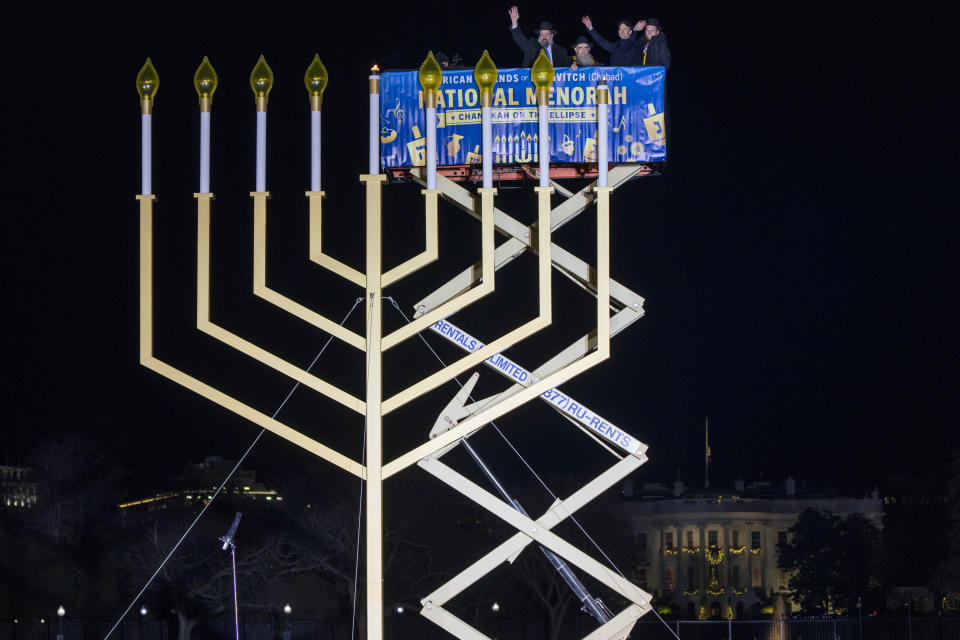 FILE - The National Chanukah Menorah is lit by Rabbi Levi Shemtov, at left, with his father Abraham Shemtov, both of the American Friends of Lubavitch (Chabad), and others wave after lighting the menorah, Thursday, Dec. 7, 2023, on the ellipse of the White House complex in Washington. (AP Photo/Jacquelyn Martin, File)