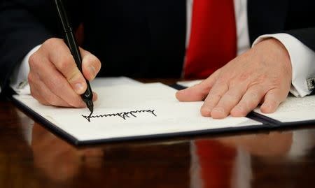 U.S. President Donald Trump signs an executive order on immigration policy in the Oval Office of the White House in Washington, U.S., June 20, 2018. REUTERS/Leah Millis