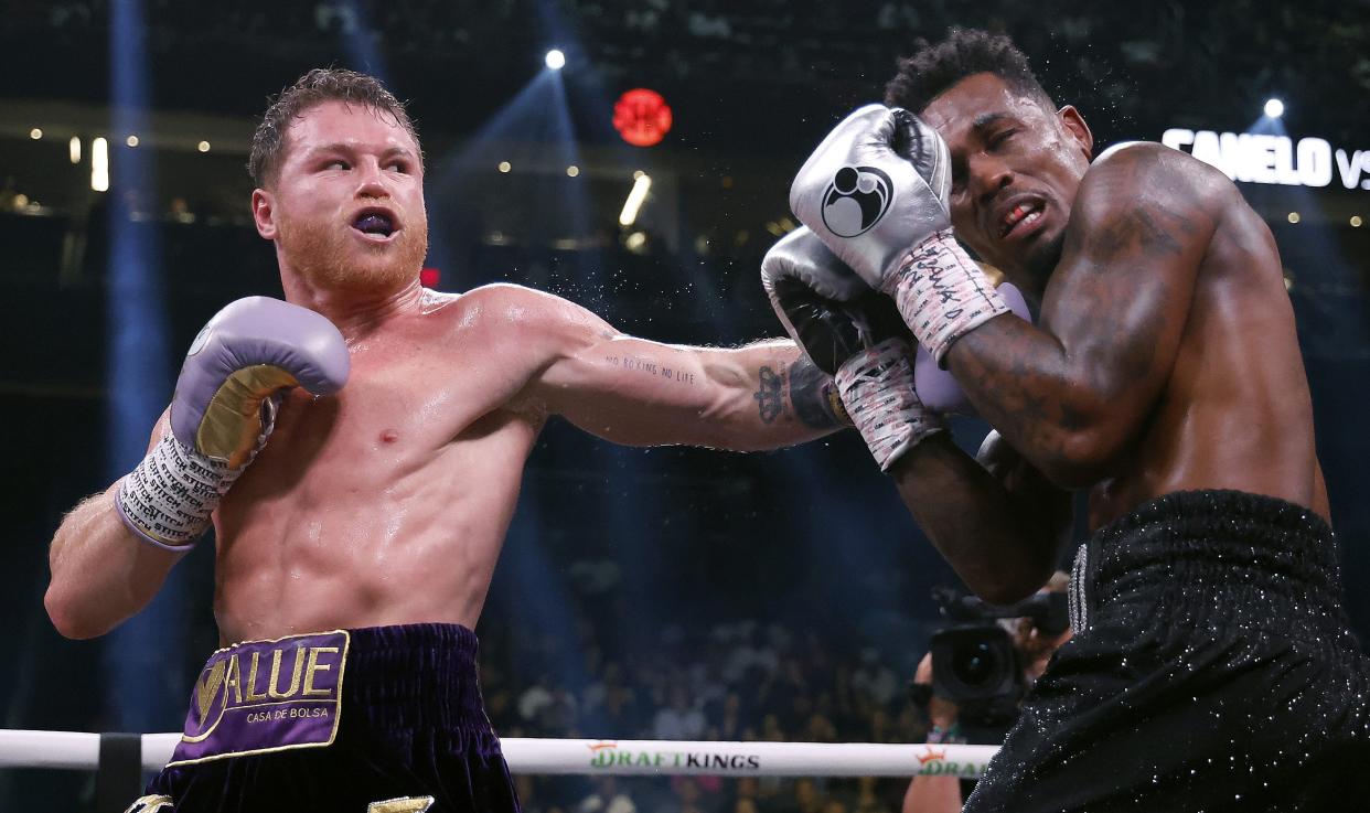 LAS VEGAS, NEVADA - SEPTEMBER 30:  Saul "Canelo" Alvarez of Mexico (purple/gold trunks) trades punches with Jermell Charlo (black trunks) during their super middleweight title fight at T-Mobile Arena on September 30, 2023 in Las Vegas, Nevada. (Photo by Sarah Stier/Getty Images)