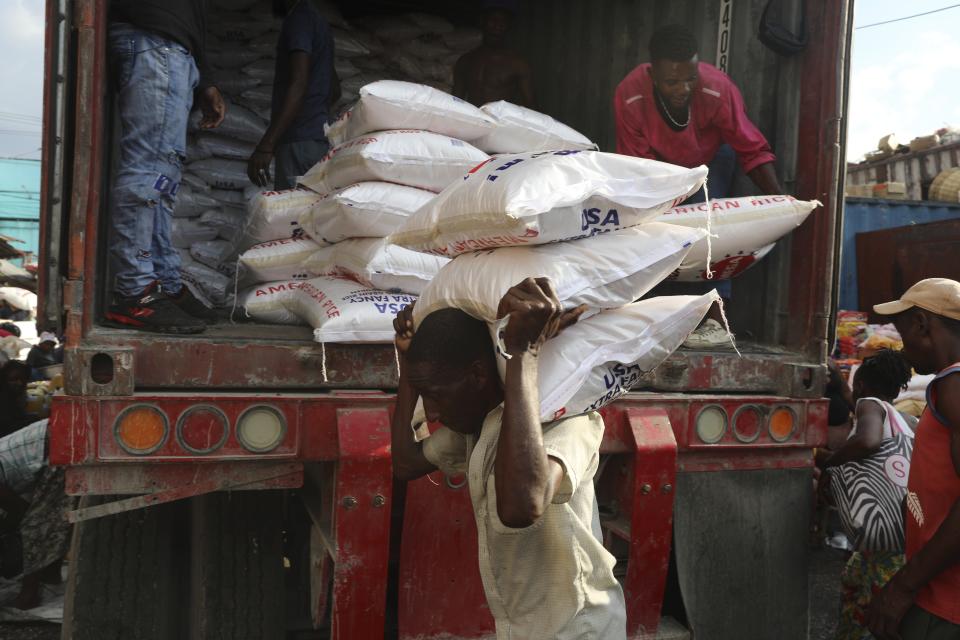 A worker unloads sacks of rice at a market in the Petion-Ville neighborhood of Port-au-Prince, Haiti, Wednesday, April 10, 2024. (AP Photo/Odelyn Joseph)