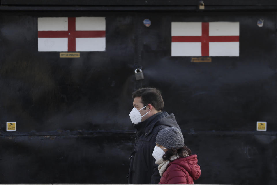 Pedestrians pass a closed souvenir stand in London, Saturday, Jan. 23, 2021 during England's third national lockdown since the coronavirus outbreak began. The U.K. is under an indefinite national lockdown to curb the spread of the new variant, with nonessential shops, gyms and hairdressers closed, and people being told to stay at home. (AP Photo/Kirsty Wigglesworth)