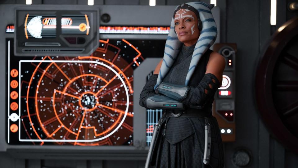 Ahsoka stands in front of a heads-up display screen