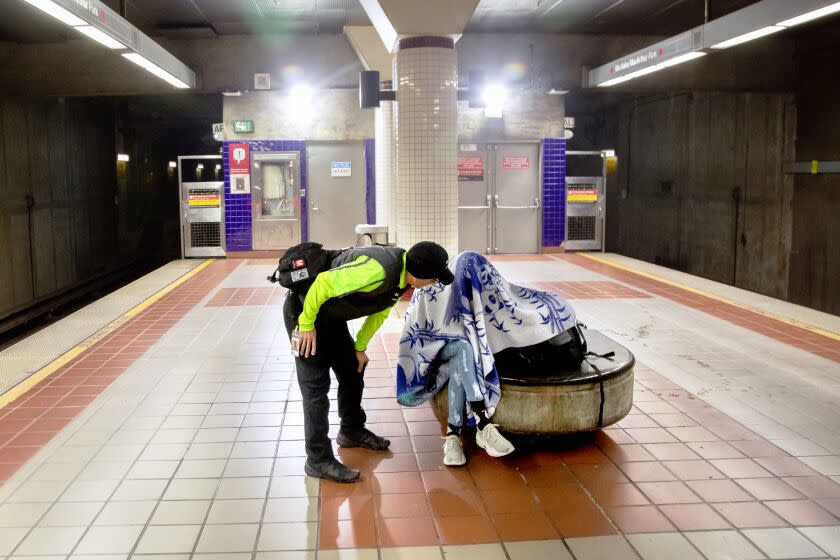 LOS ANGELES, CA - JUNE 07: Fabian Bolanos, a Metro Ambassador, checks on a visitor at the Metro Westlake / MacArthur Park station. He and other amabassadors are equipped with Narcan, for opioid overdoses, as well as a CPR resuscitator mask kit. During his shift, he has revived people with drug overdoses. Photographed on Wednesday, June 7, 2023. (Myung J. Chun / Los Angeles Times)