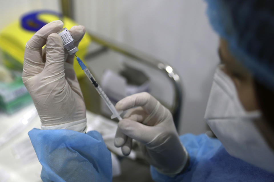 Staff nurse Lina Tannoury prepares a shot of the Pfizer's COVID-19 vaccine at Saint George Hospital University Medical Center, in Beirut, Lebanon, Tuesday, April 6, 2021. Human Rights Watch, a leading rights group, said that Lebanon's vaccination campaign has been slow and risks leaving behind some of the country's most vulnerable people, including Palestinian and Syrian refugees, as well as migrant workers. (AP Photo/Bilal Hussein)