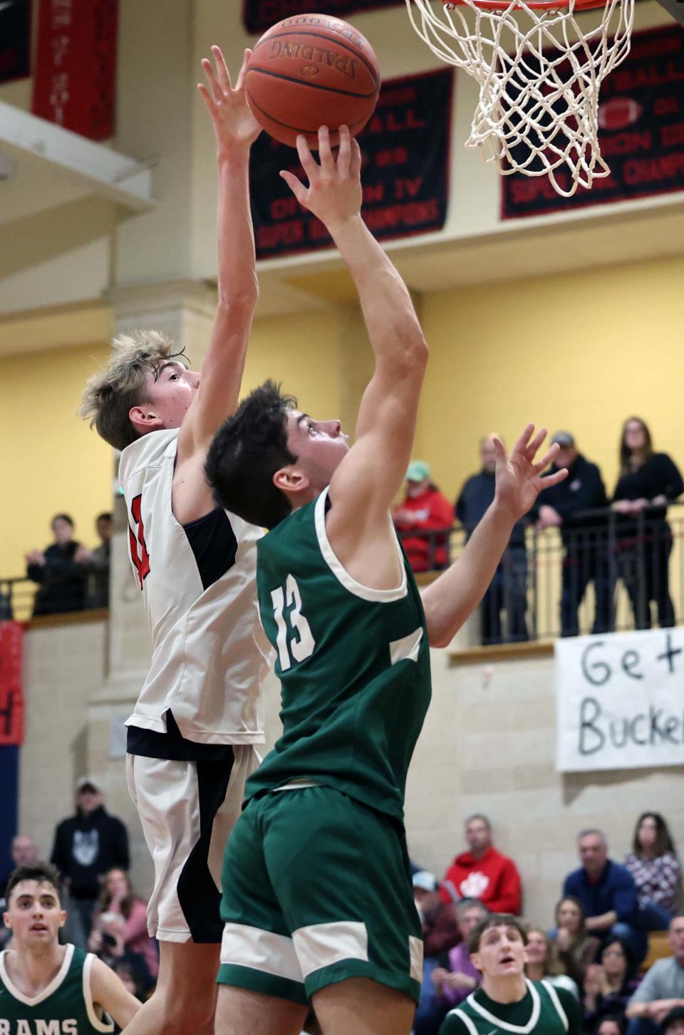 Marshfield's Jake Brilliant takes a shot at the basket on Whitman-Hanson defender Ryan Baker during a game  on Friday, Feb. 10, 2023.