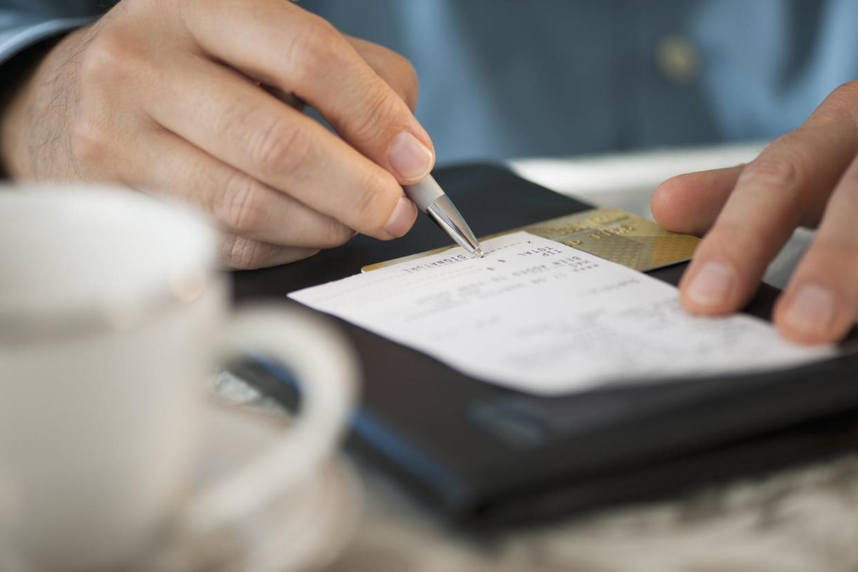 Man signing bill at restaurant