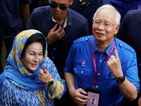 Malaysia's Prime Minister Najib Razak of Barisan Nasional (National Front) and his wife Rosmah Mansor show their ink-stained fingers after voting in Malaysia's general election in Pekan, Pahang, Malaysia, May 9, 2018. REUTERS/Athit Perawongmetha/Files