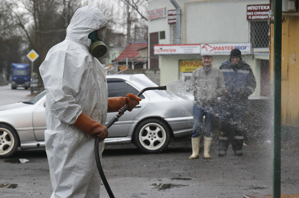 A specialist from a local veterinary service wears a protective suit as sprays disinfectant near a food shop in Kirovsk, about 30 kilometres (19 miles) east of St.Petersburg, Russia, Thursday, April 2, 2020. The new coronavirus causes mild or moderate symptoms for most people, but for some, especially older adults and people with existing health problems, it can cause more severe illness or death. (AP Photo/Dmitri Lovetsky)