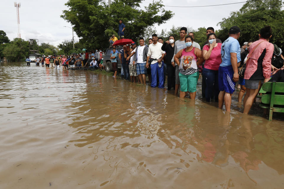 Residents wait for help to be rescued from a flooded area in the neighborhood of Planeta, Honduras, Thursday, Nov. 5, 2020. The storm that hit Nicaragua as a Category 4 hurricane on Tuesday had become more of a vast tropical rainstorm, but it was advancing so slowly and dumping so much rain that much of Central America remained on high alert. (AP Photo/Delmer Martinez)