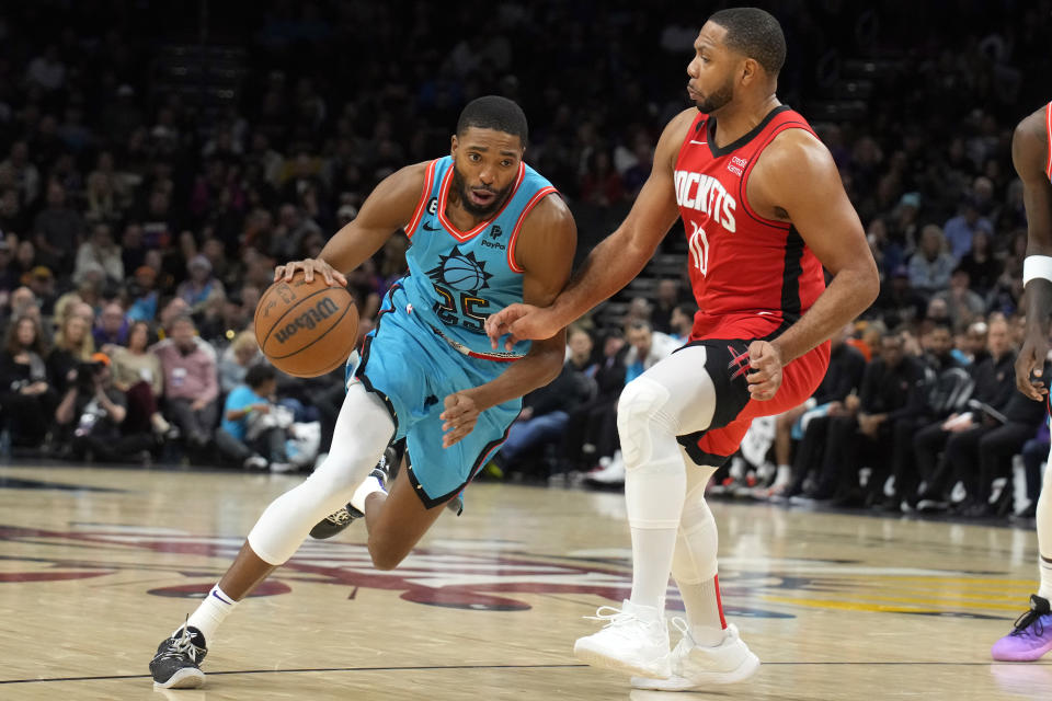 Phoenix Suns forward Mikal Bridges (25) drives on Houston Rockets guard Eric Gordon during the second half of an NBA basketball game Friday, Dec. 2, 2022, in Phoenix. The Rockets won 122-121. (AP Photo/Rick Scuteri)