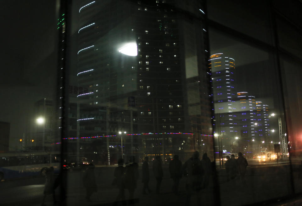 In this Tuesday Feb. 25, 2014 photo, North Koreans walk on a street at a residential complex which is lit at night in Pyongyang, North Korea. (AP Photo/Vincent Yu)