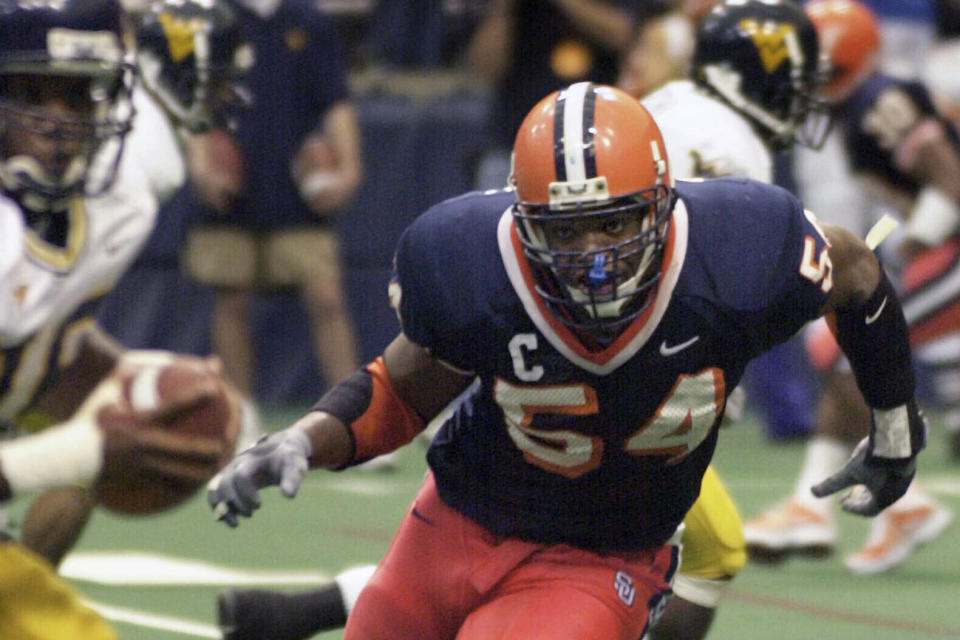 FILE - In this Nov. 10, 2001, file photo, Syracuse defensive end Dwight Freeney (54) bares down on West Virginia quarterback Rasheed Marshall during the fourth quarter of an NCAA college football game, in Syracuse, N.Y. Georgia cornerback Champ Bailey, Syracuse defensive end Dwight Freeney and Kansas State running back Darren Sproles will appear on the College Hall of Fame ballot for the first time. The National Football Foundation announced Tuesday, June 16, 2020, the 78 players and seven coaches from major college who are up for selection to the Hall of Fame. (AP Photo/Kevin Rivoli, File)