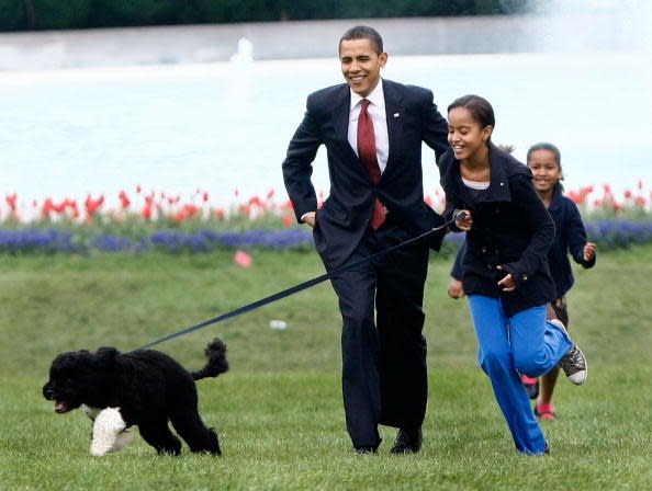 U.S. President Barack Obama with his daughters Malia (C) and Sasha (R) walk the family's new Portuguese water dog Bo, during the dog's introduction to the White House press corps on the South Lawn of the White House April 14, 2009 in Washington, DC. The six-month-old puppy is a gift from Sen. Edward M. Kennedy (D-MA) who owns several Portuguese water dogs himself. This breed of dog is considered a good pet for children who have allergies, as Malia does. (Photo by Win McNamee/Getty Images)
